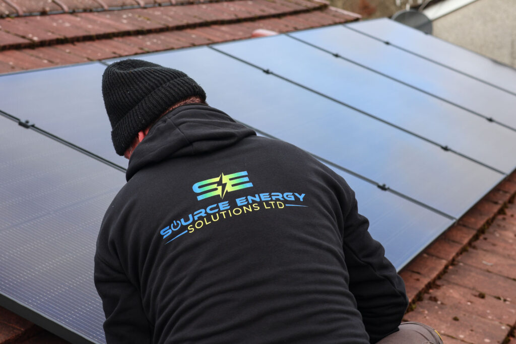 man installing solar panels on a roof