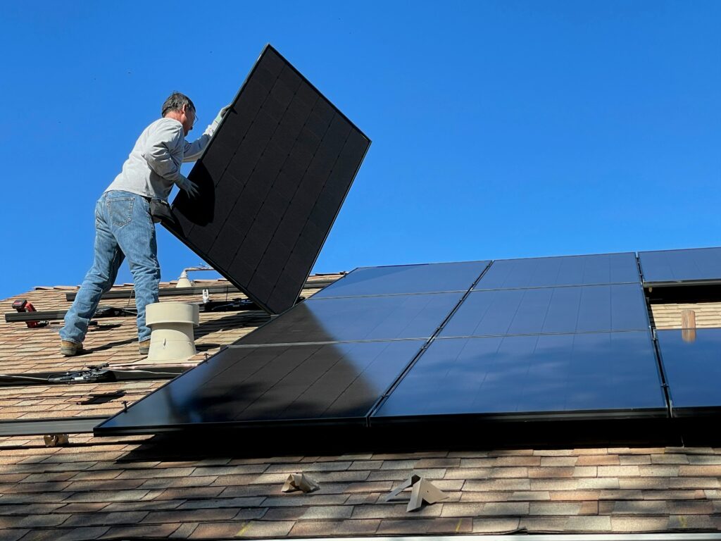 man fixing solar panels to a roof