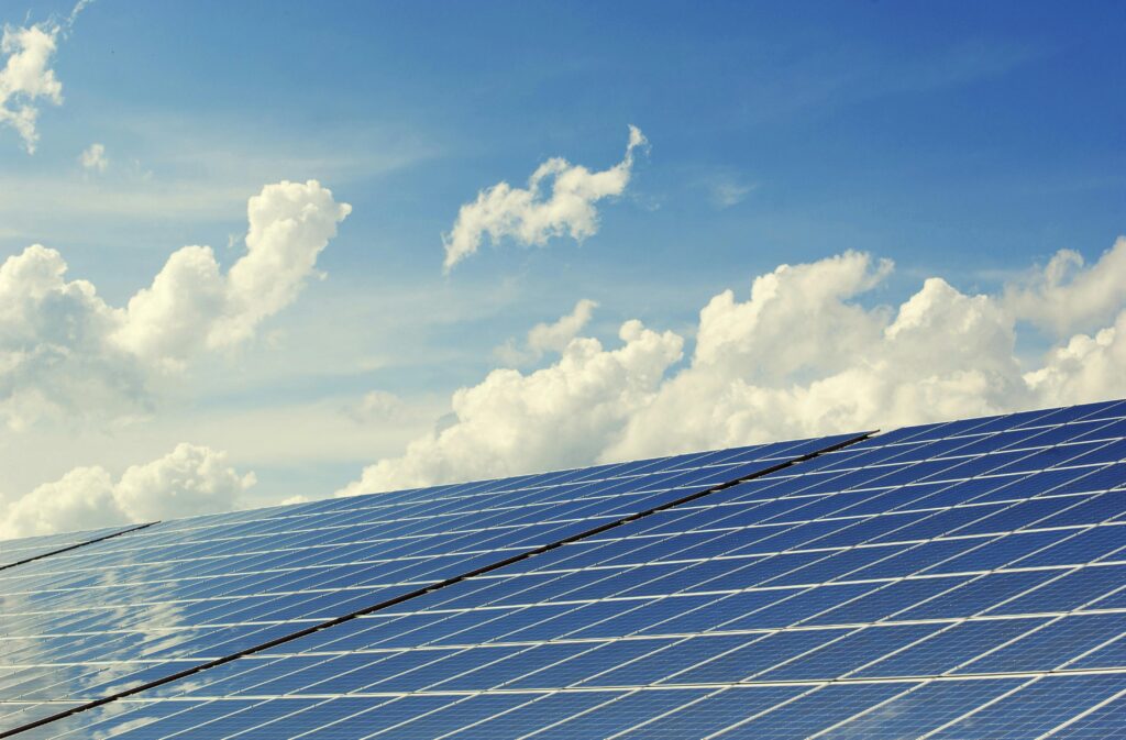 a solar panel farm with clouds in the background